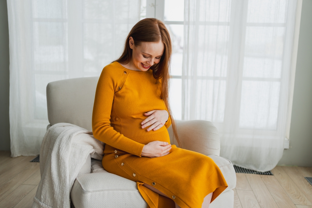 happy pregnant woman looking at her bump